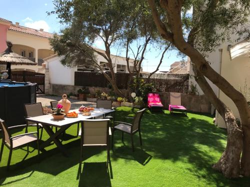a backyard with a table and chairs and a tree at Ca Na Clar in Sa Ràpita