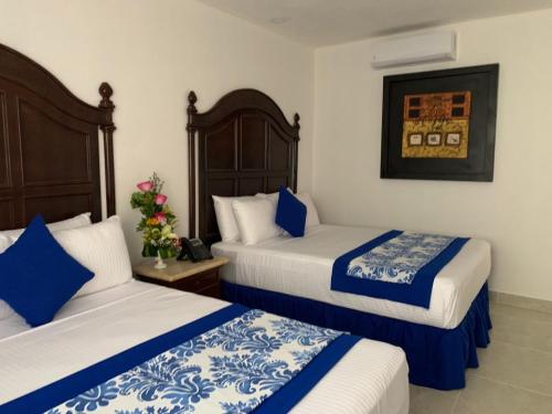 سرير أو أسرّة في غرفة في Hotel Catedral Valladolid Yucatan