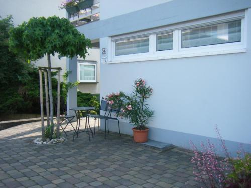 a patio with a table and chairs in front of a building at Ferienwohnung M. Lemmermeyer in Neumagen-Dhron