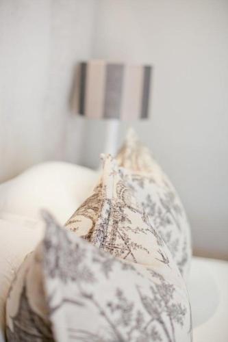a pillow on a white couch with a lamp at Banksia Boutique Hotel & Spa in Cape Town