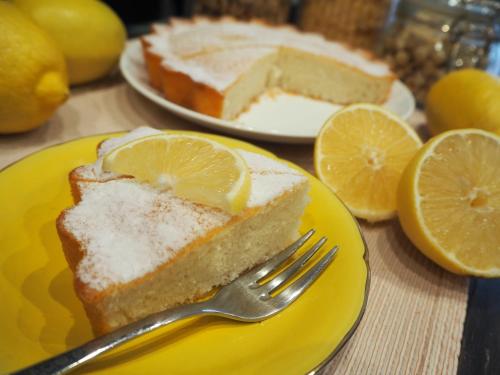 a piece of lemon cake on a yellow plate with a fork at Albergo Diffuso Sotto le Cummerse in Locorotondo
