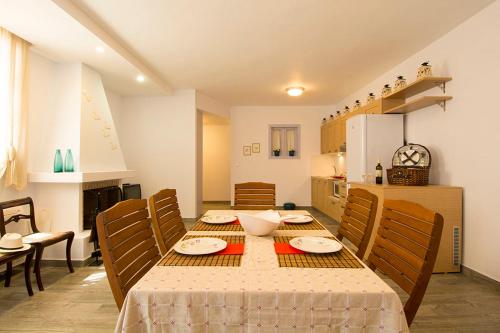 a dining room with a table and chairs and a kitchen at VILLA AELIA in Spetses - charm & convenience, 2min beach in Spetses