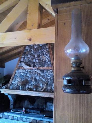 a light hanging from a wooden ceiling with a fireplace at вила Здравец in Yagodina