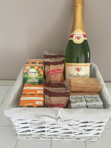 - un panier avec une bouteille de champagne et d'autres aliments dans l'établissement Fonclaire Holidays Glamping 'Luxury Camping', à Blond