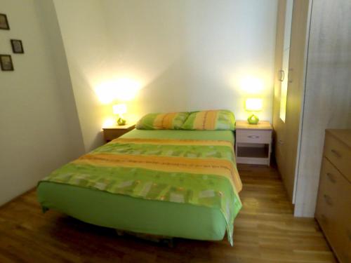 two beds in a small room with two lamps at Green Apartman in Rafailovici