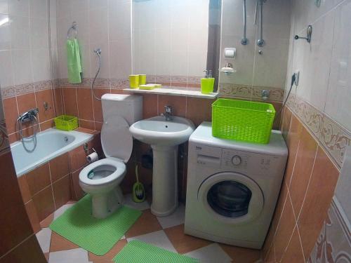 a bathroom with a toilet a sink and a washing machine at Green Apartman in Rafailovici