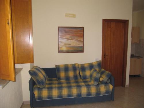 a plaid couch in a living room with a painting at Agriturismo Torre Del Golfo in Cropani