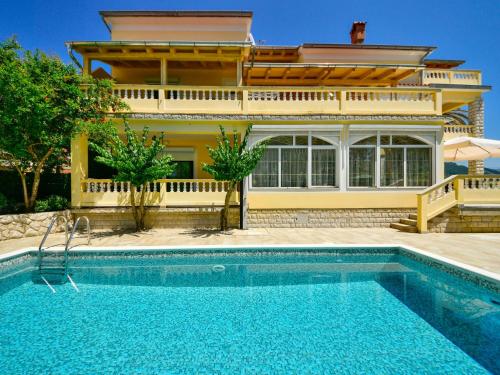 a house with a swimming pool in front of a house at Apartment Olga-5 by Interhome in Rab