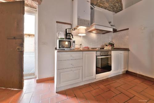 a kitchen with white cabinets and a microwave at Agriturismo La Gioconda in Vinci