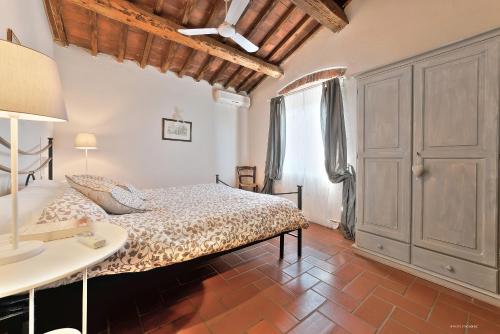 a bedroom with a bed and a table and a window at Agriturismo La Gioconda in Vinci