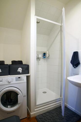 une salle de bain avec douche et machine à laver dans l'établissement T2 de charme N4 Valenciennes Netflix, Wifi, à Aulnoy
