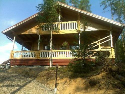 a large wooden house with a porch on a hill at Holiday Home Käkiharju by Interhome in Sulkava