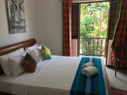 a bedroom with a bed with towels on it at Pick & Go White House in Negombo