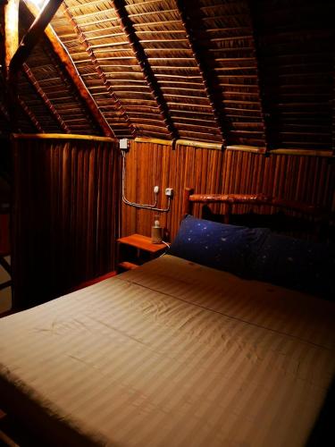 una camera da letto con un letto in una stanza di legno di CHEZ ALEX a Nosy Be