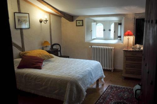 Landevieille的住宿－Logis de la Robliniere，一间卧室配有一张床、一个梳妆台和一扇窗户。