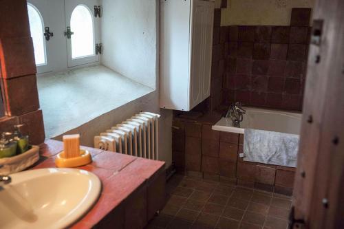 Landevieille的住宿－Logis de la Robliniere，浴室配有盥洗盆和浴缸。