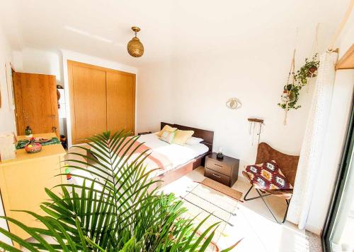 a bedroom with a bed and a chair in it at Casa Mawi in Sagres