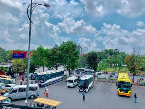 eine Gruppe von Bussen und Autos auf einem Parkplatz in der Unterkunft VIỆT Hostel in Hue
