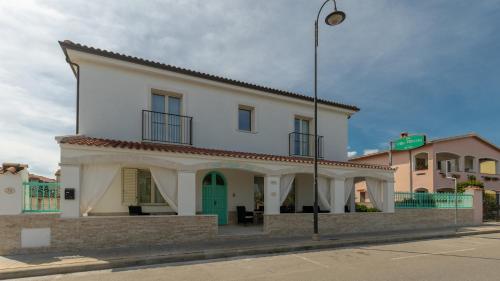 a white building with a green door on a street at Villa Alberta Hotel in Pula