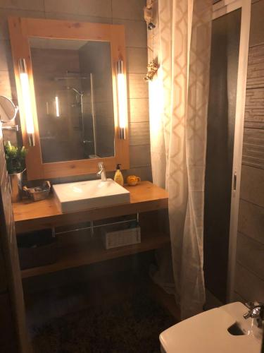 een badkamer met een wastafel en een spiegel en een toilet bij Family-Appartment in Santa Pola