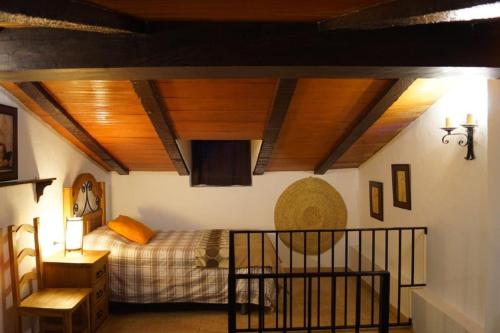 a bedroom with a bed and a wooden ceiling at Casa Rural Recreo in El Gastor