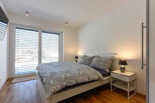 a bedroom with a bed and a large window at Seechalet in Altossiach