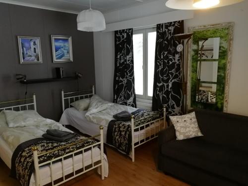 a bedroom with two beds and a couch and a window at Vuotson Maja B&B in Vuotso