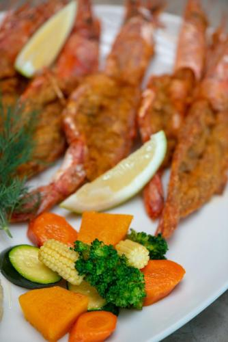 a plate of food with fish and vegetables on it at Nkomazi Kruger Lodge & Spa in Malelane