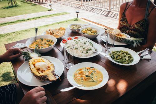 a woman sitting at a table with plates of food at Amber House Lanka in Bentota