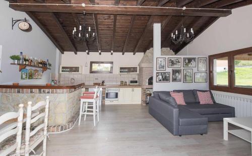 a living room with a couch and a kitchen at Villa El tinganon in Llanes