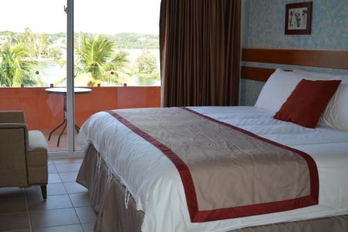 a hotel room with a bed and a balcony at Peten Esplendido in Flores