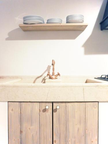 two plates on a shelf above a sink at Albergo Diffuso Sotto le Cummerse in Locorotondo