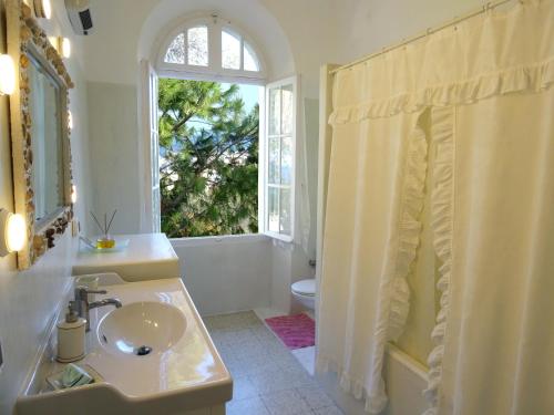 a white bathroom with a sink and a window at Romantic rooms with stunning sea view in Rhodes Town
