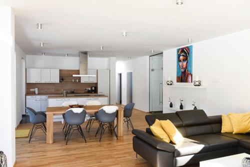 a living room with a couch and a table and a kitchen at Seechalet in Altossiach
