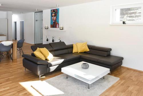 a living room with a black couch and a table at Seechalet in Altossiach