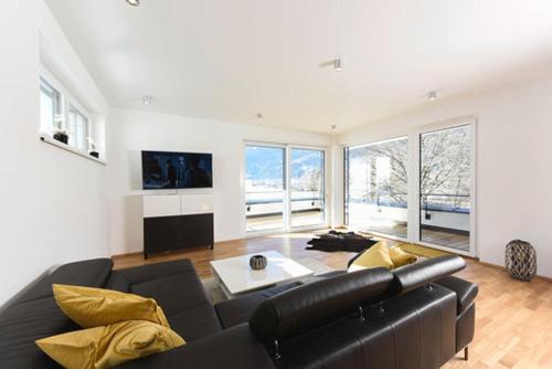 a large living room with a black leather couch at Seechalet in Altossiach