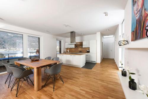 a kitchen and dining room with a wooden table and chairs at Seechalet in Altossiach
