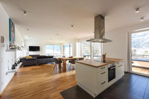a kitchen and living room with a table and a couch at Seechalet in Altossiach