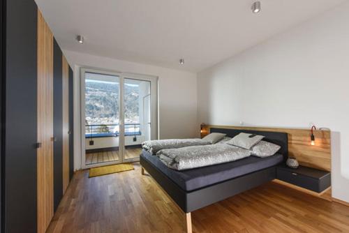 a bedroom with a bed and a large window at Seechalet in Altossiach