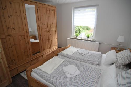 1 Schlafzimmer mit 2 Betten, einem Schrank und einem Fenster in der Unterkunft Ferienhaus kleine Villa in Marschkamp