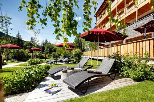 un patio con sillas y sombrillas en Hotel Monika, en Sesto