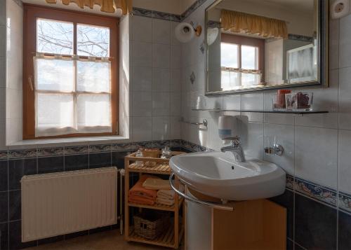 La salle de bains est pourvue d'un lavabo et d'un miroir. dans l'établissement Guesthouse Tulipan, à Lesce