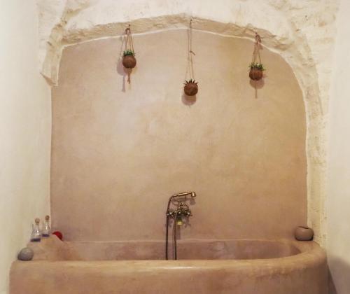 a bath tub in a bathroom with plants on the wall at Albergo Diffuso Sotto le Cummerse in Locorotondo