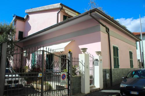 een roze huis met een hek ervoor bij La Casa dei Fiori in La Spezia