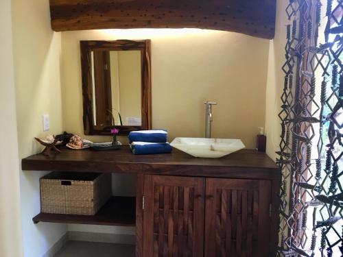 uma casa de banho com um lavatório e um espelho em Un Escondite Mágico em Barra de Potosi