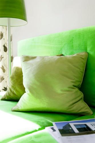 a green bed with a pillow and a table with a lamp at Schlegelhof in Kirchzarten