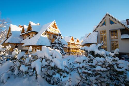 a house covered in snow at Aparthotel Bellamonte in Zakopane