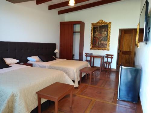 a hotel room with two beds and a table at Casa Hacienda Nasca Oasis in Nazca