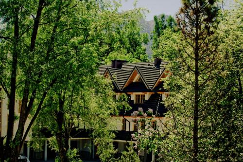 a house in the middle of some trees at Aparthotel Bellamonte in Zakopane