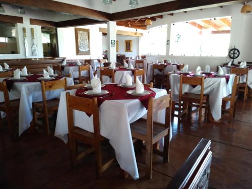 a restaurant with tables and chairs with white tablecloths at Casa Hacienda Nasca Oasis in Nazca